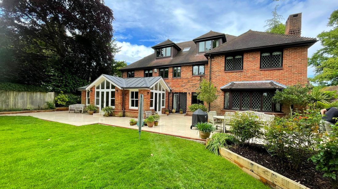 Premium sandstone patio laid by Flint Landscaping behind a brick house